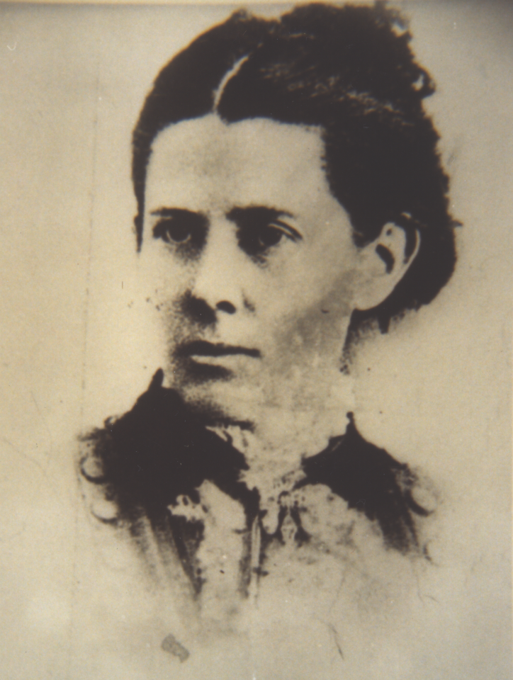 Close-up of a man's face in a faded sepia photograph, showing eyes, nose and mustache, cropped to the left side of the frame.