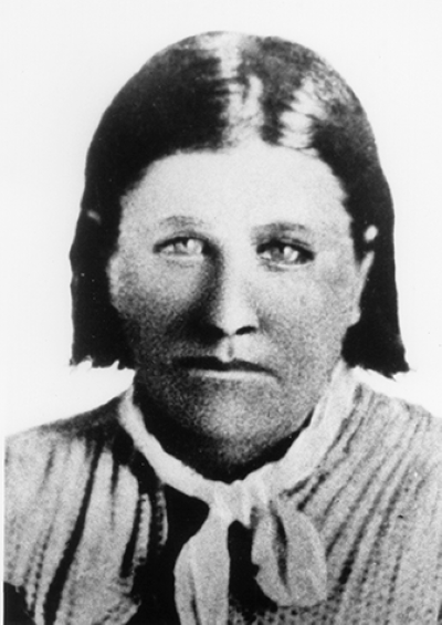 Historical black-and-white portrait of a woman with dark hair, wearing a light blouse and neck scarf, facing the camera.